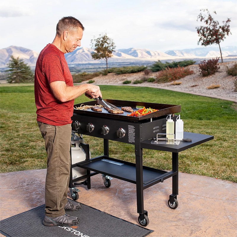 man cooking on a flat top grill