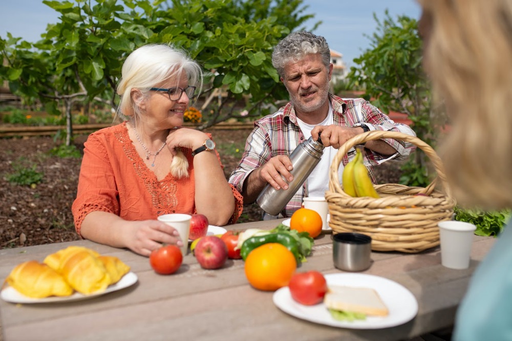 seniors eating outside at a table